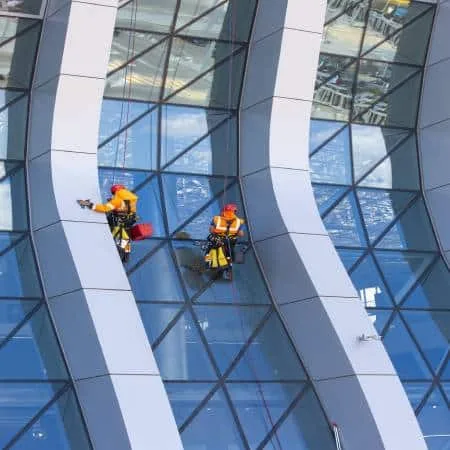 window-cleaner-working-glass-facade-modern-skyscraper почистване на стъклена фасада